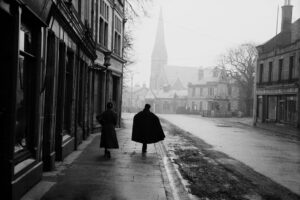 A man and a woman walk down an unknown street in Edinburgh, Scotland in 1953.